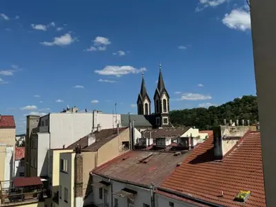 a view of a city with a church and roofs at Vitkova Duplex apartment with terrace near Florenc in Prague