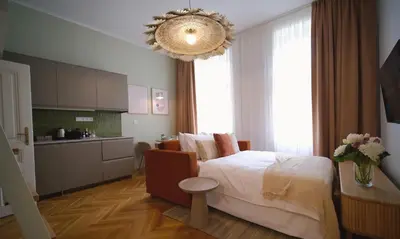 a bedroom with a large bed and a kitchen at Luxemi Apartments I City Center Premium Studio in Prague