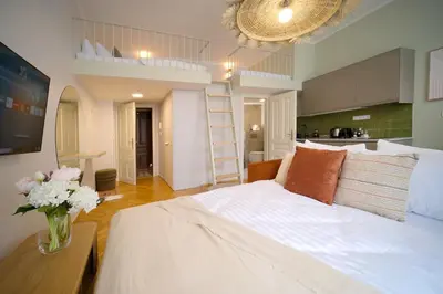 a bedroom with a white bed and a vase of flowers at Luxemi Apartments I City Center Premium Studio in Prague