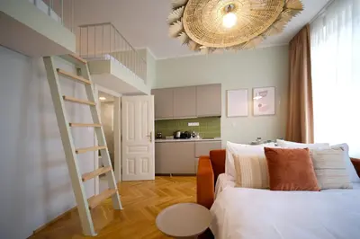 a bedroom with a ladder and a bed and a kitchen at Luxemi Apartments I City Center Premium Studio in Prague