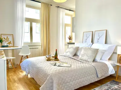 a bedroom with a large bed with a white bedspread at Treetess City Centre Prague Apartments in Prague