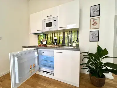 a kitchen with white cabinets and a microwave at Treetess City Centre Prague Apartments in Prague