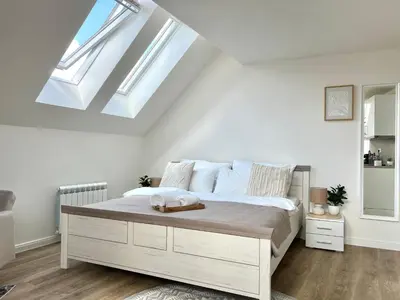 a bedroom with a large bed with skylights at Treetess City Centre Prague Apartments in Prague