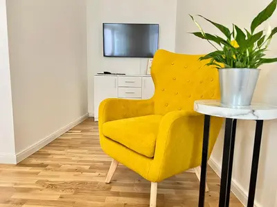 a yellow chair and a table with a potted plant at Treetess City Centre Prague Apartments in Prague