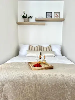 a bed with a tray of food and drinks on it at Treetess City Centre Prague Apartments in Prague