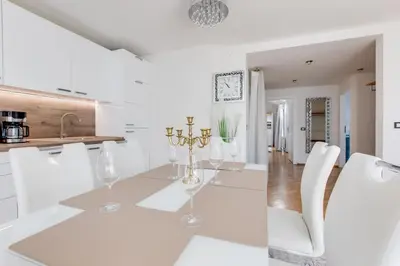 a white kitchen with a dining table and chairs at Wenceslas Square Royal Apartments in Prague