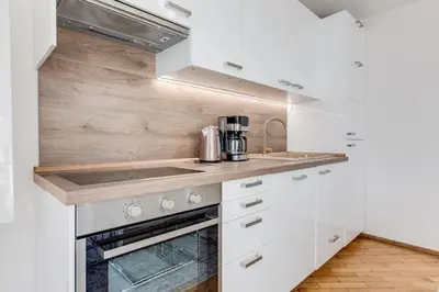 a kitchen with white cabinets and a counter top at Wenceslas Square Royal Apartments in Prague