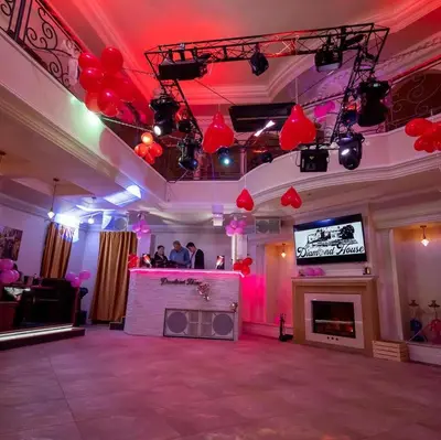 a room with a stage with red balloons and a tv at DiamondHouse vila & wellness in Kolín