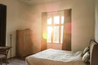 a bedroom with a bed and a window at Villa Lobkovice: Gemütliches Gästehaus am Schloss in Lobkovice