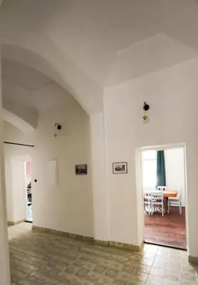 an empty room with white walls and a dining room at Villa Lobkovice: Gemütliches Gästehaus am Schloss in Lobkovice