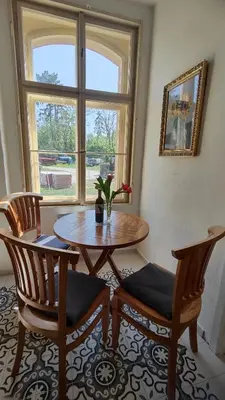 a room with a table and two chairs and a window at Villa Lobkovice: Gemütliches Gästehaus am Schloss in Lobkovice