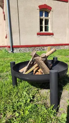 a fire pit in the grass in front of a building at Villa Lobkovice: Gemütliches Gästehaus am Schloss in Lobkovice