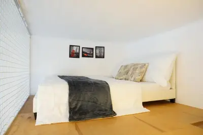 a bed in a room with three pictures on the wall at 3Brothers Homestay in Prague