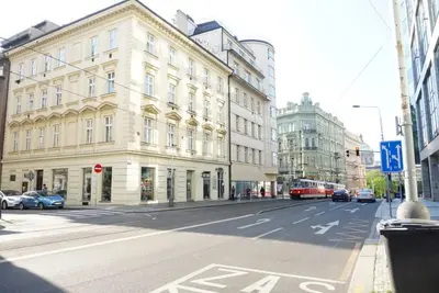 an empty city street with buildings and cars on the road at 3Brothers Homestay in Prague