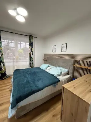a bedroom with a large bed and a wooden table at Pražský byt s dobrou dostupností in Prague