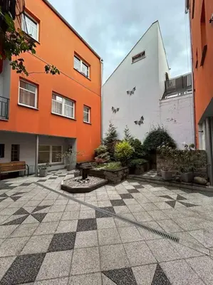 a courtyard with an orange and white building at Pražský byt s dobrou dostupností in Prague