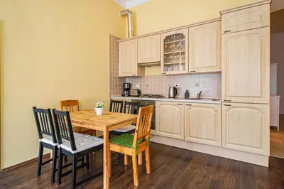 a kitchen with a wooden table and chairs at Spacious oasis in Prague's Heart in Prague