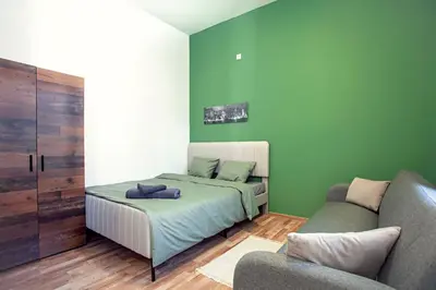 a green bedroom with a bed and a couch at The Tranquil Palace in Prague