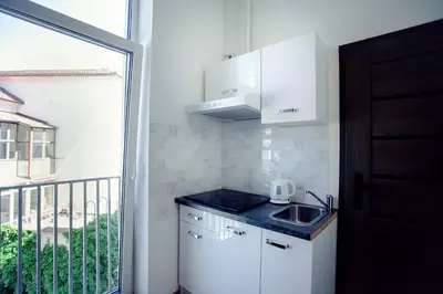 a small kitchen with a sink and a balcony at The Tranquil Palace in Prague