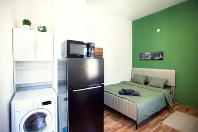 a small room with a refrigerator and a bed at The Tranquil Palace in Prague