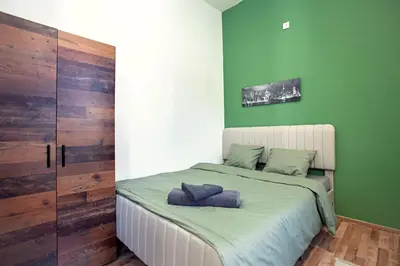 a bedroom with green walls and a bed with two pillows at The Tranquil Palace in Prague
