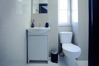 a white bathroom with a toilet and a sink at The Tranquil Palace in Prague