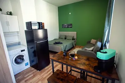 a small living room with a refrigerator and a table at The Tranquil Palace in Prague