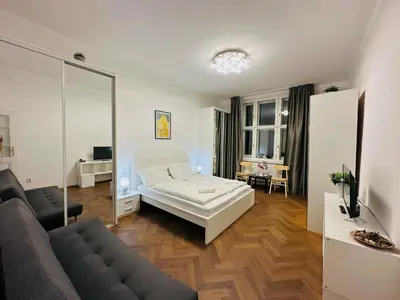 a living room with a bed and a couch at Maiselova Old Town Apartment in Prague