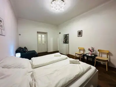 a bedroom with two beds and a chandelier at Maiselova Old Town Apartment in Prague
