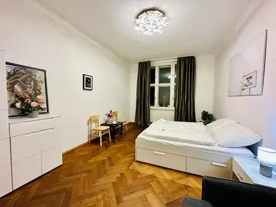 a bedroom with a bed and a desk and a window at Maiselova Old Town Apartment in Prague