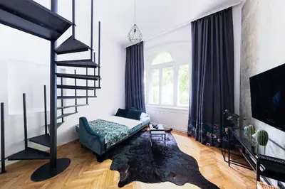 a bedroom with a loft bed and a spiral staircase at Bohéme Apartments - Karlín in Prague