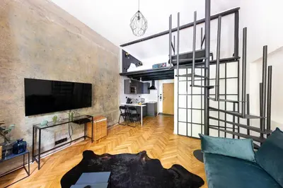 a living room with a couch and a tv at Bohéme Apartments - Karlín in Prague
