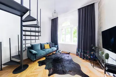 a living room with a blue couch and a tv at Bohéme Apartments - Karlín in Prague