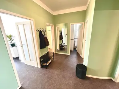 a room with green walls and two mirrors and a hallway at Luxury Apartment in Old Town in Prague