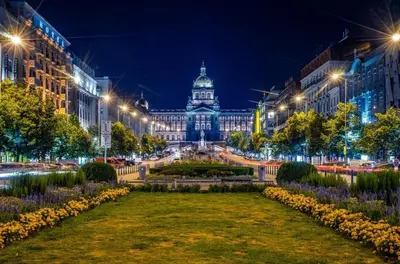 a park in front of a large building at night at Best location in Prague! 4 bedrooms and super host! in Prague