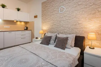 a bedroom with a bed and a brick wall at Old Town Square Studio in Prague