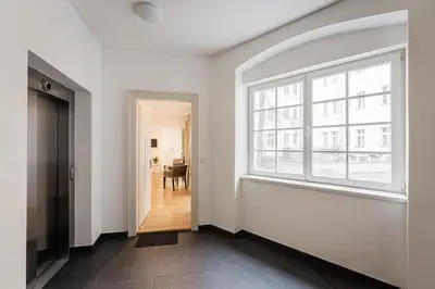 an empty hallway with a large window and a table at Old Town Square Studio in Prague