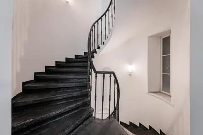 a black staircase in a white room with a window at Old Town Square Studio in Prague
