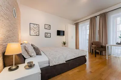 a bedroom with a bed and a table with a lamp at Old Town Square Studio in Prague