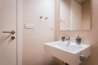 a white bathroom with a sink and a shower at Old Town Square Studio in Prague
