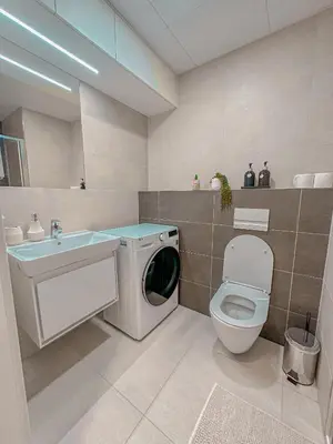 a bathroom with a washing machine and a toilet at My Mozartova in Prague