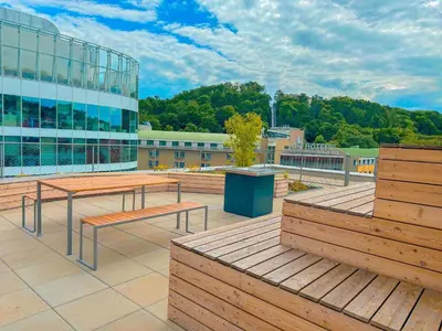 a building with two benches and a building with trees at My Mozartova in Prague