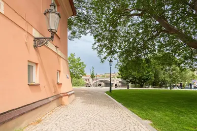 a cobblestone street in a park next to a building at River View Apartment in Prague