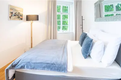 a bedroom with a white bed with blue pillows at River View Apartment in Prague