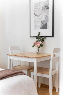 a white dining room table with a vase of flowers on it at 1# Fancy share Apartment with Own Bathroom in Prague