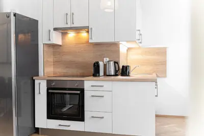a kitchen with white cabinets and a black oven at 1# Fancy share Apartment with Own Bathroom in Prague