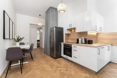 a kitchen with white cabinets and a table and a refrigerator at 1# Fancy share Apartment with Own Bathroom in Prague