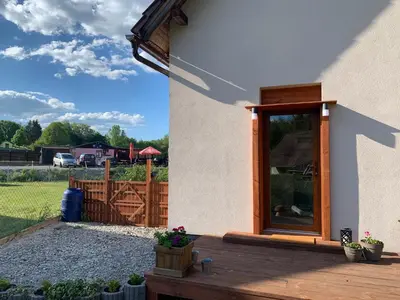 a house with a wooden porch with a fence at Apartment Nedamov in Dubá