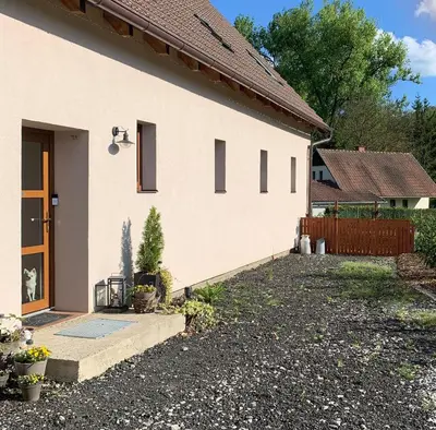 a white house with a door and a yard at Apartment Nedamov in Dubá
