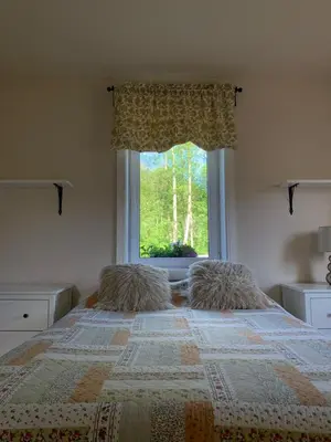 a bedroom with a bed with a large window at Apartment Nedamov in Dubá